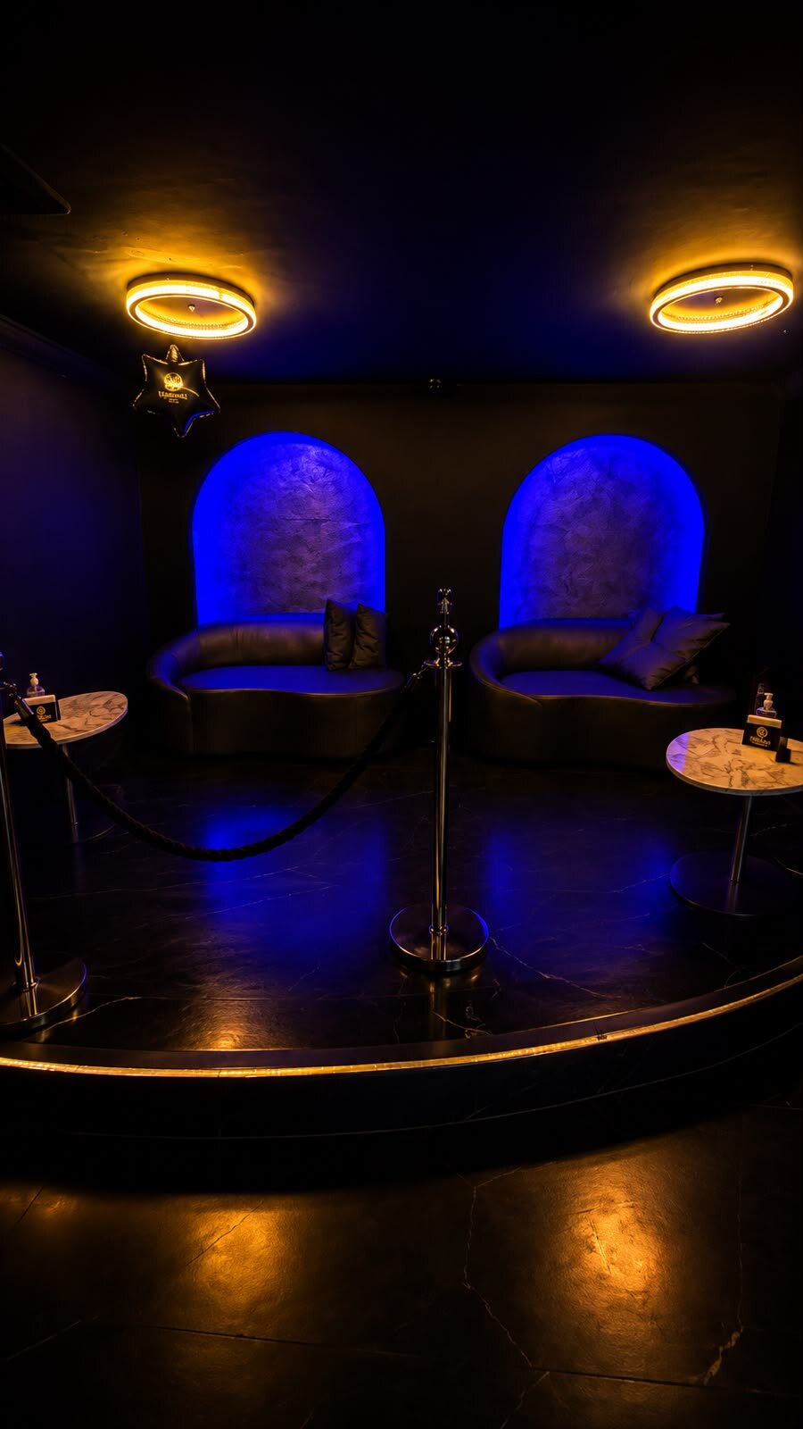 Nichos em arco com sofás e luz azul no Opium Club SP