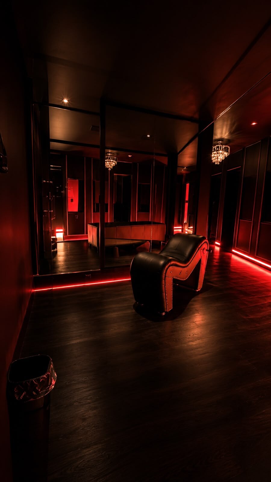 Ambiente reservado com poltrona e luz vermelha no Opium Club SP